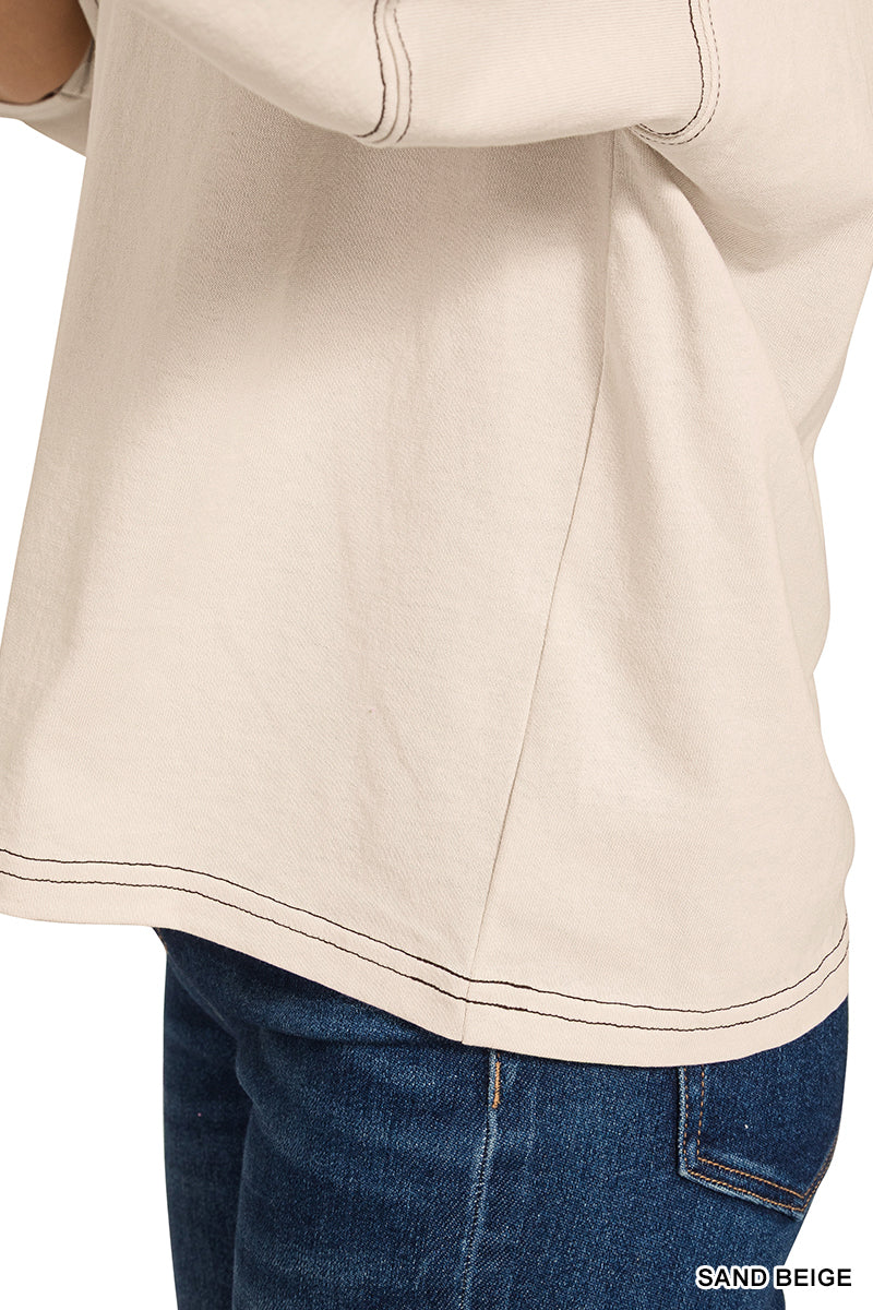 Close-up of a sand beige shirt with blue jeans on a white background