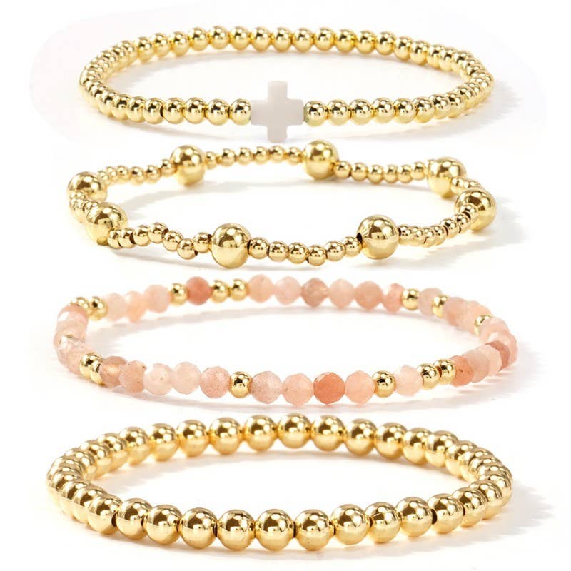 Set of gold beaded bracelets on a white background