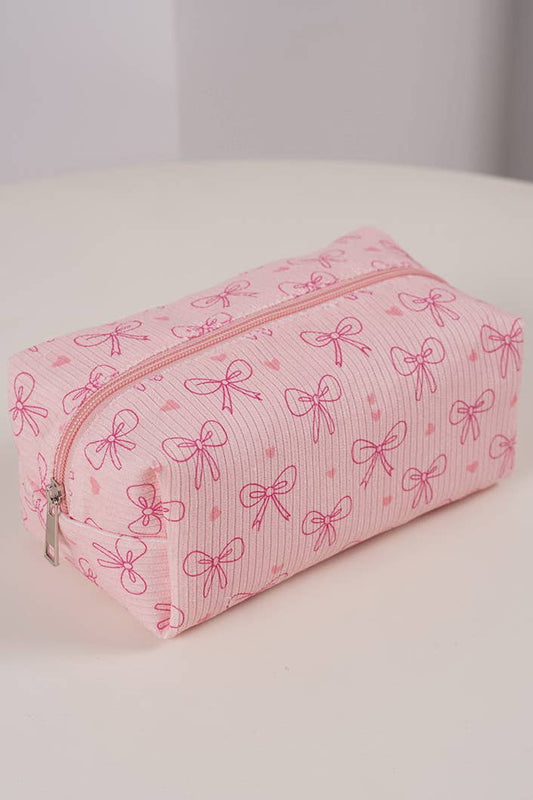 Pink cosmetic bag with bow pattern on a white surface