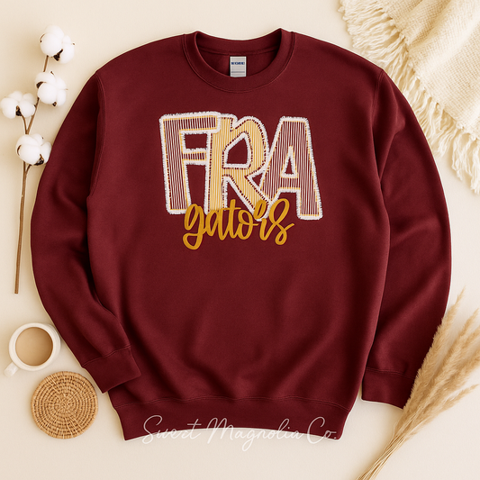 Maroon sweatshirt with 'FRA Gators' text on a neutral background