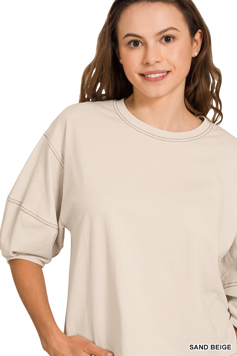 Woman wearing a sand beige top on a white background