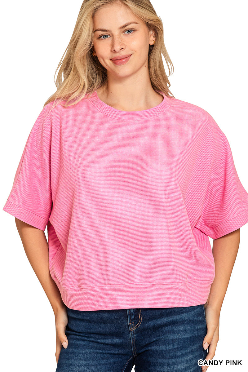Woman wearing a pink top  and blue jeans on a white background