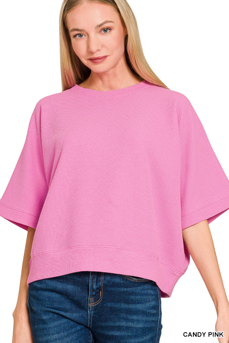 Woman wearing a pink top and blue jeans on a white background