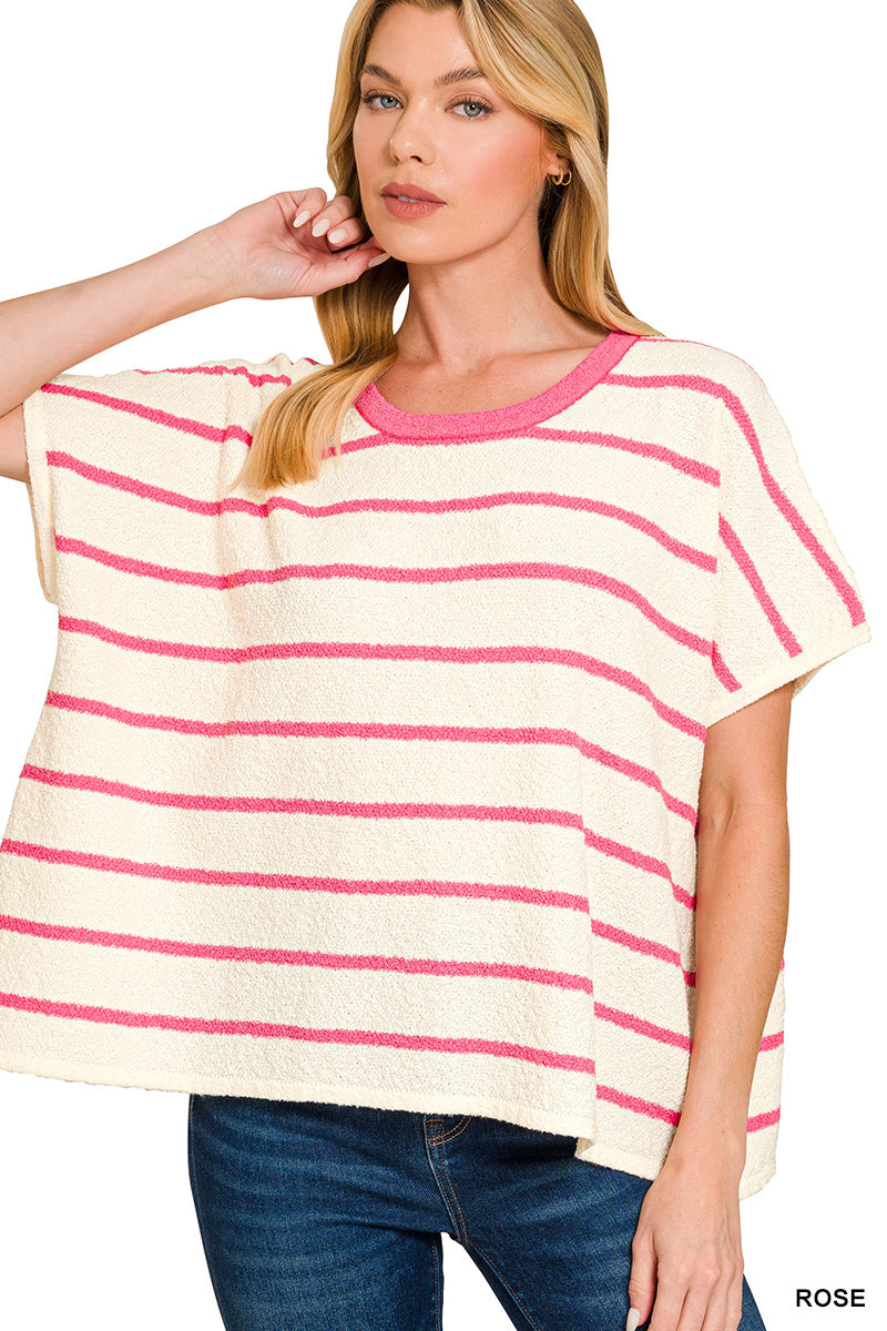 Woman wearing a cream and pink striped top with blue jeans on a white background