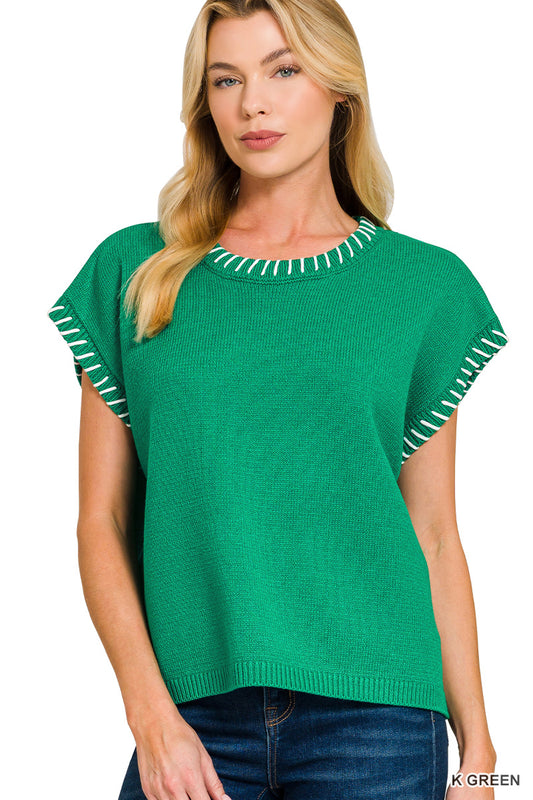 Woman wearing a green sweater with white trim on a white background